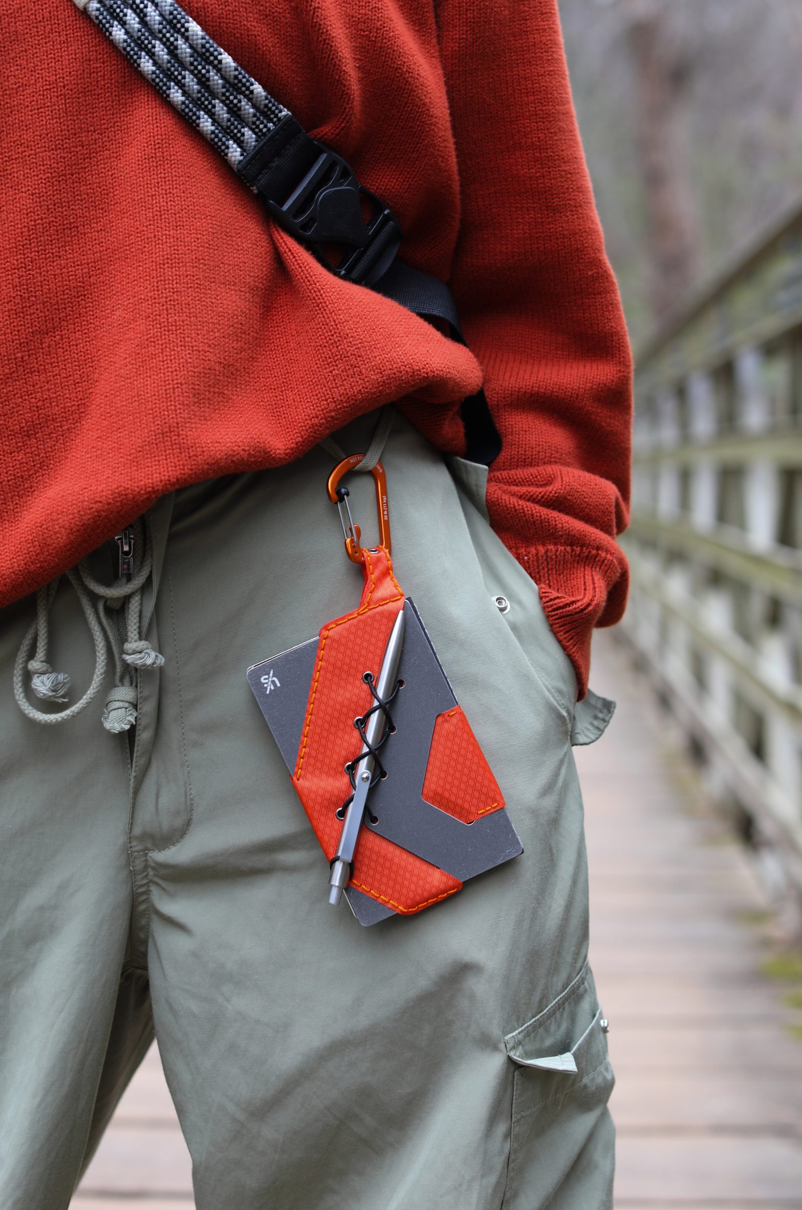 image of a red and black notebook clipped onto trousers