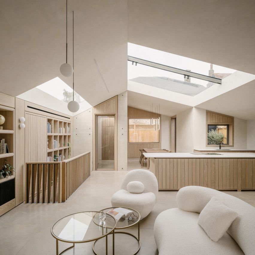 Open-plan living area with large rooflights, oak cabinetry and exposed concrete walls