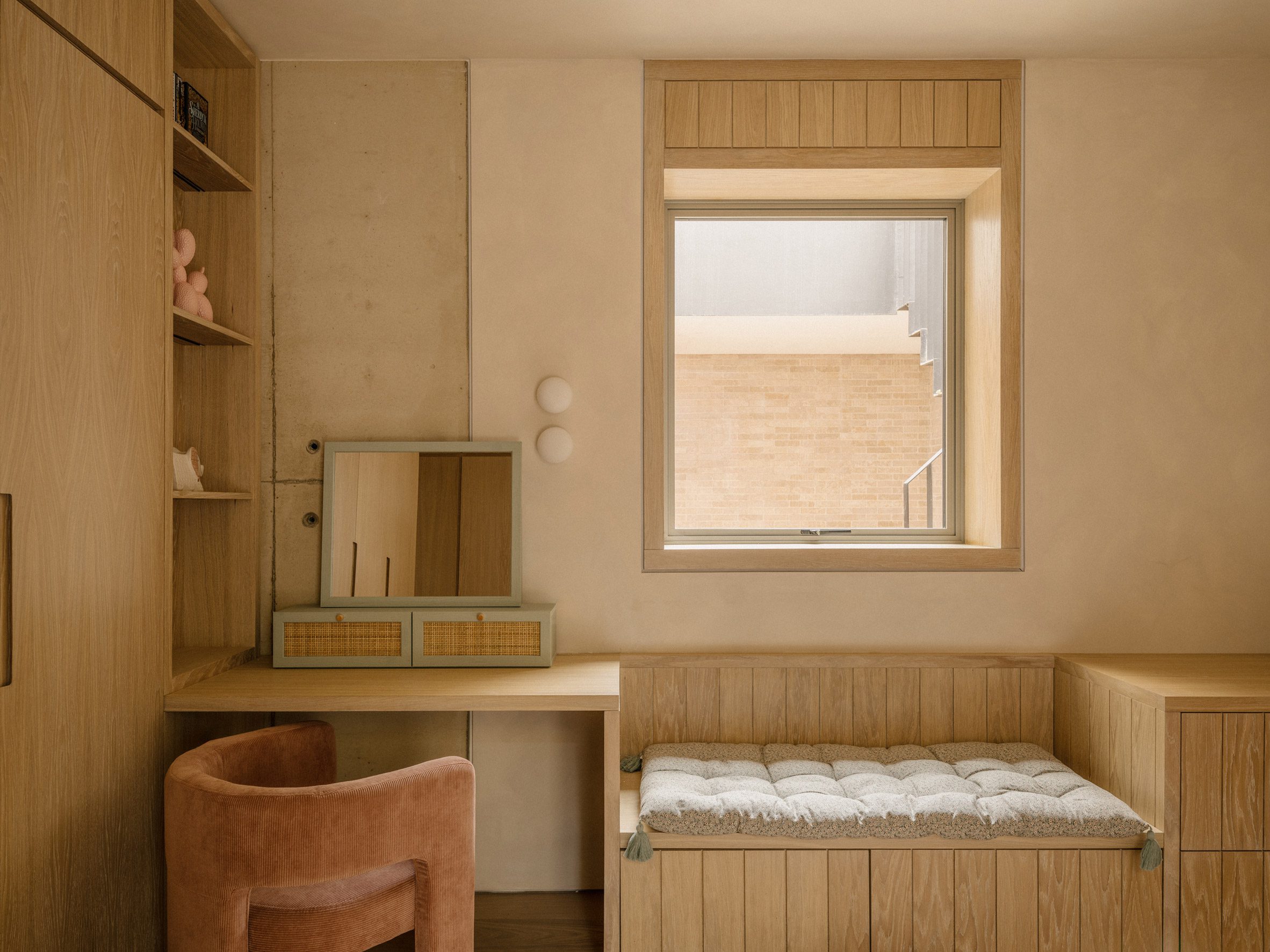 El dormitorio cuenta con un escritorio de roble integrado, armarios de almacenamiento y un asiento junto a la ventana que da al patio de luces.
