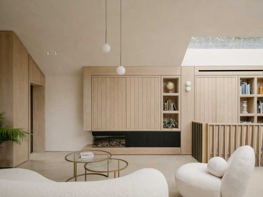 Living room with built-in oak storage and seating arranged beneath the asymmetrical roof form