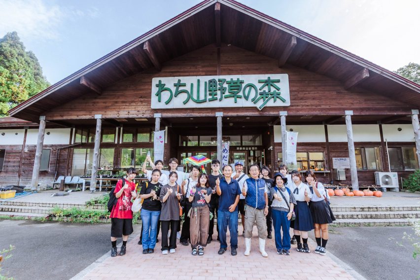 Group of people standing outside of a wooden building
