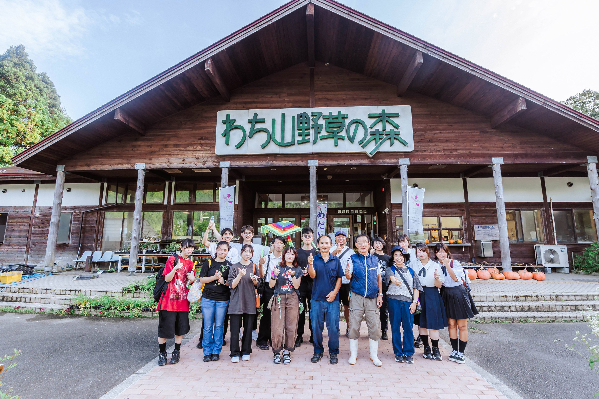 Group of people standing outside of a wooden building