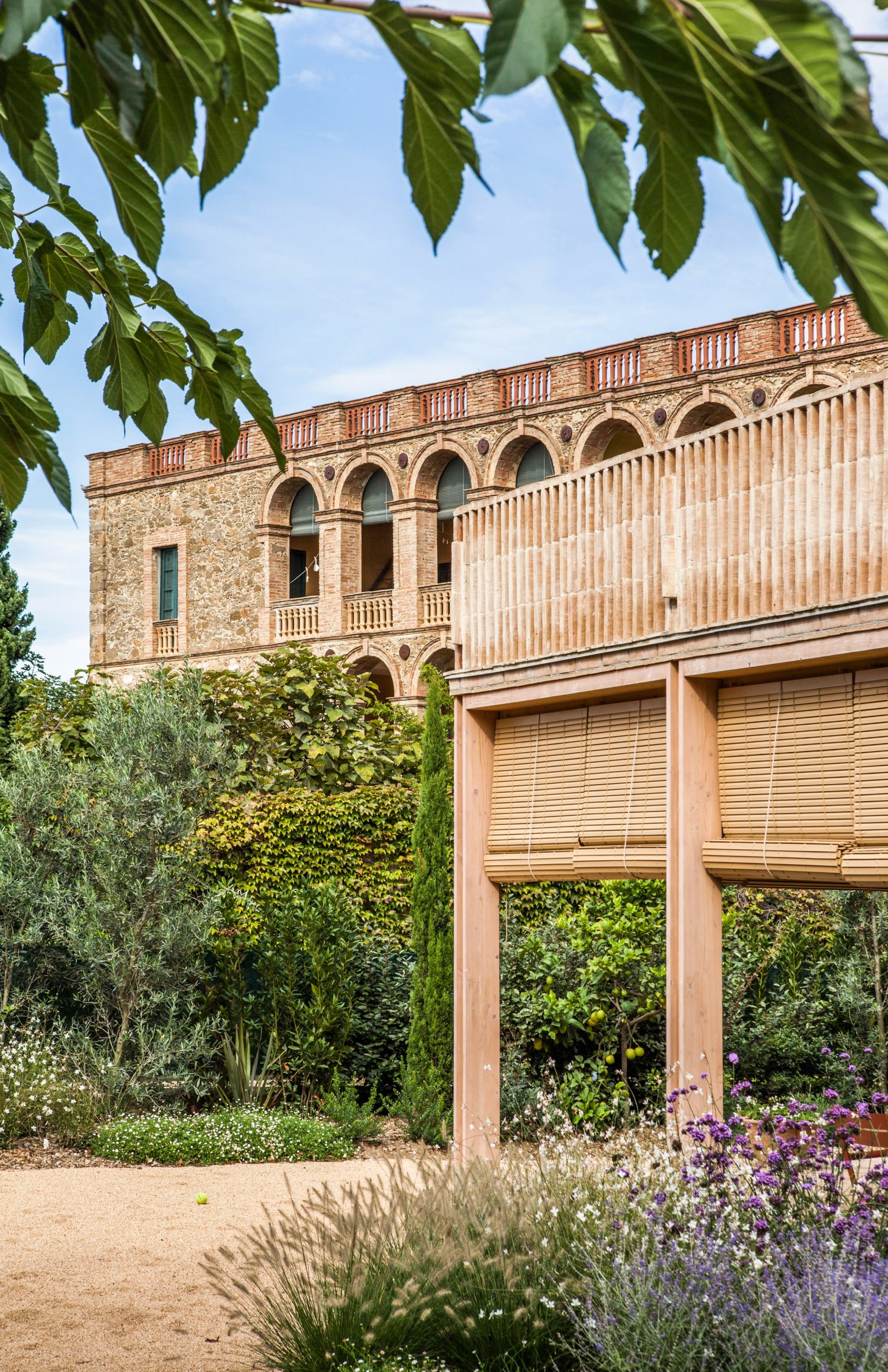 Timber-framed extension beside a historic stone building in the village of Fonolleres