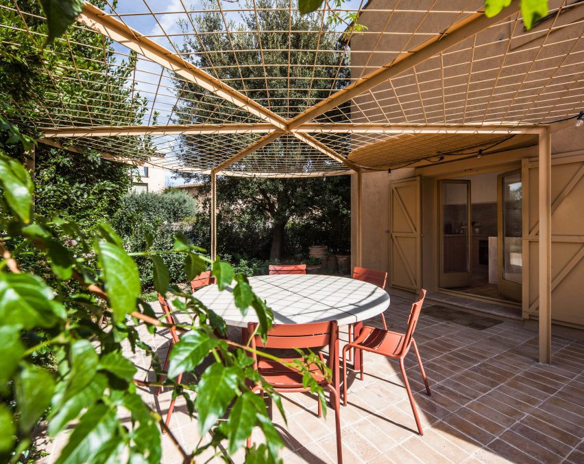 Circular pergola shading an outdoor dining area beside the house
