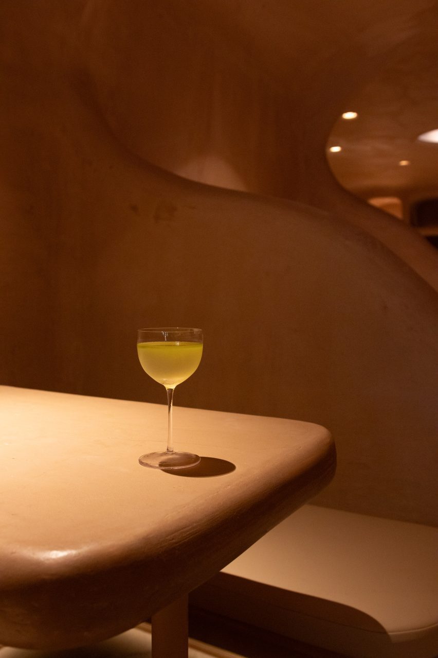 A yellow-hued cocktail in a glass on a table