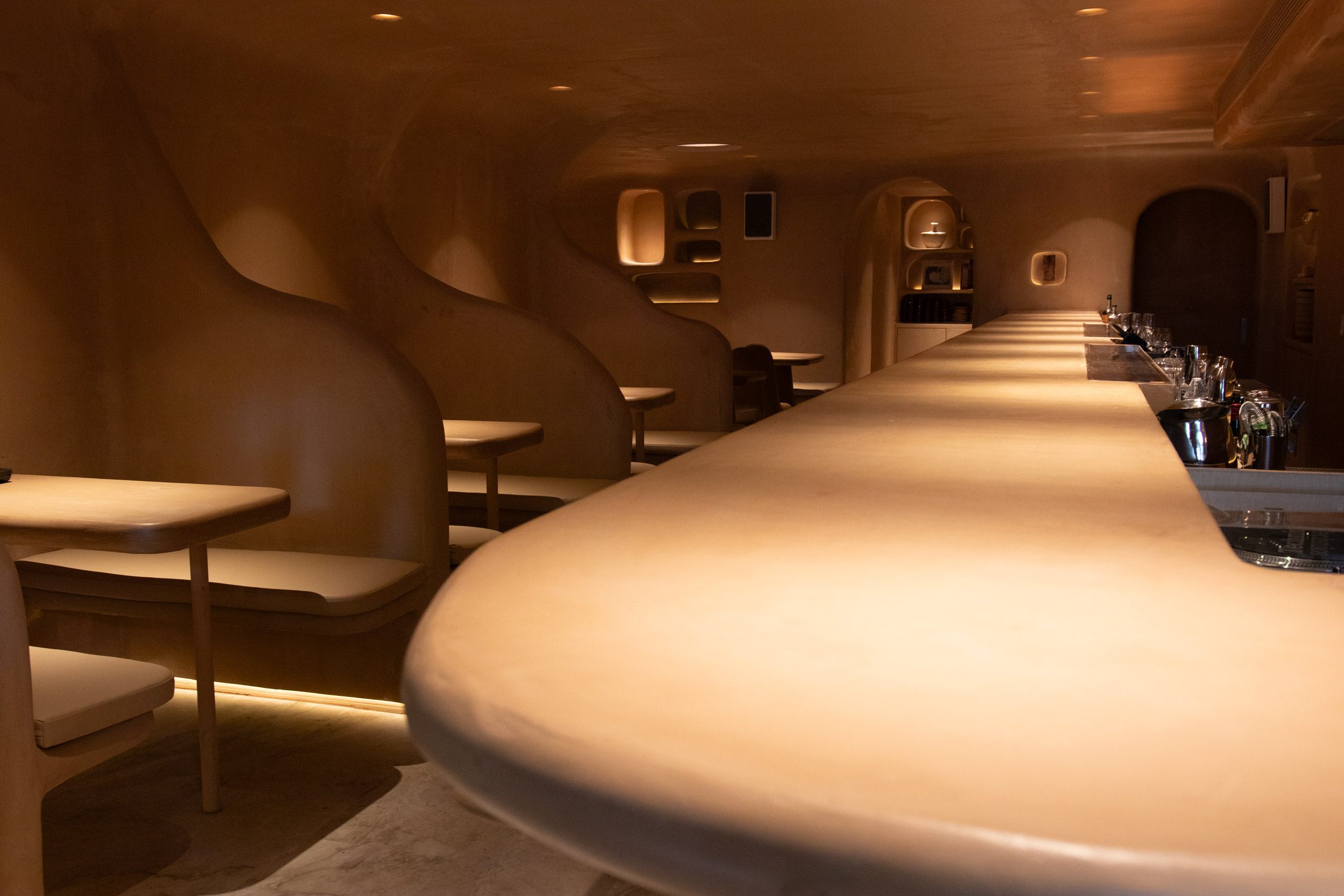 Spotlights illuminate a bar counter and tables