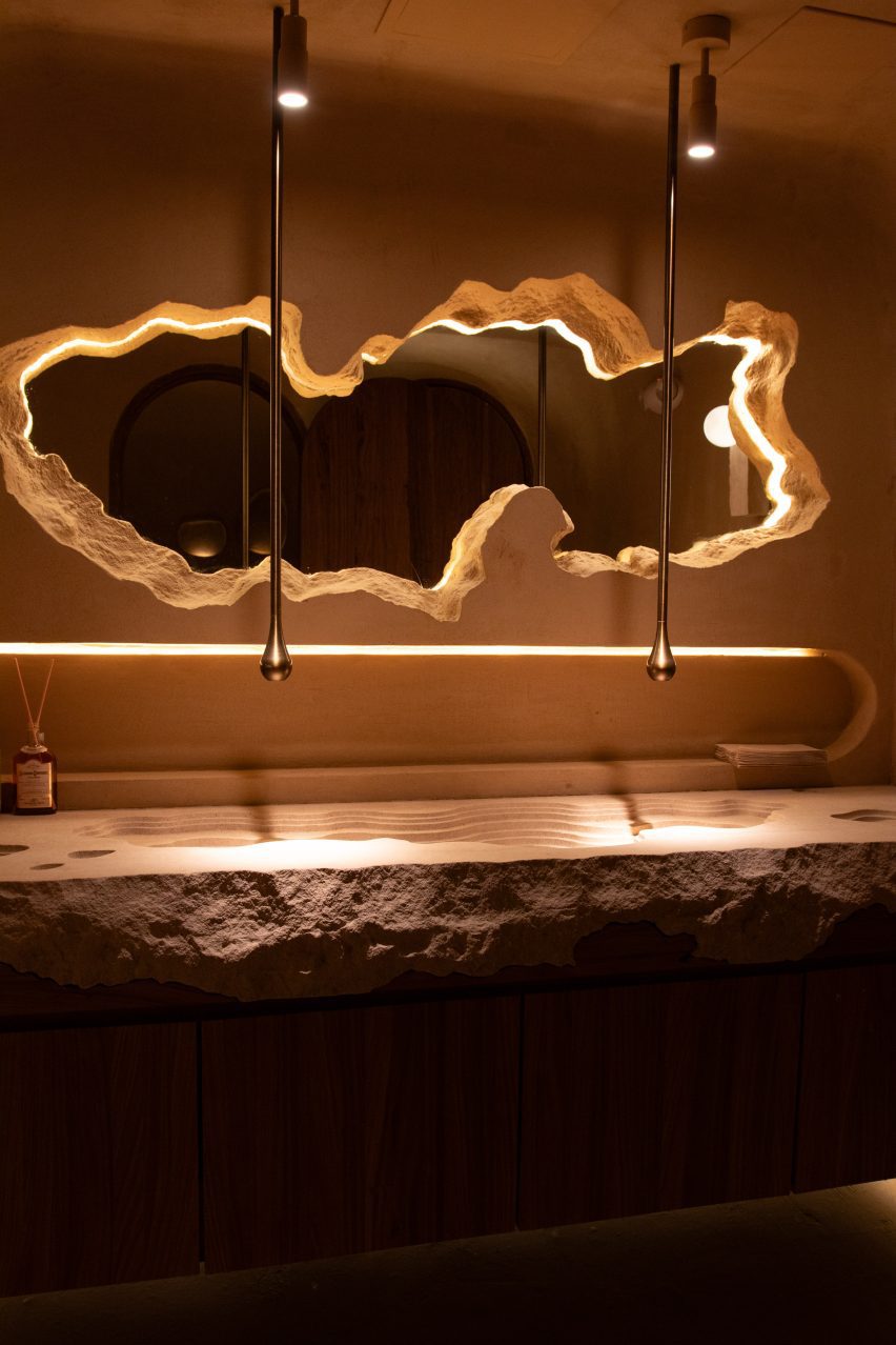 A contoured basin and faucets hanging from the ceiling