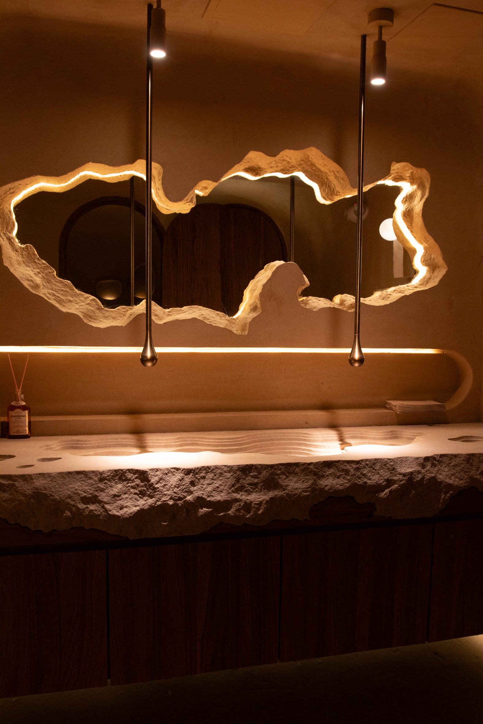 A contoured basin and faucets hanging from the ceiling