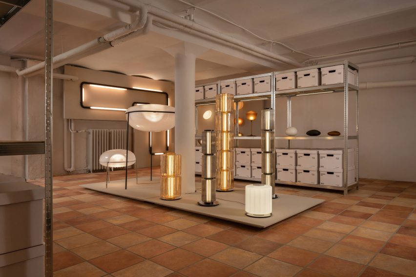 Basement showroom with tiled floors, metal shelving and sculptural lamps