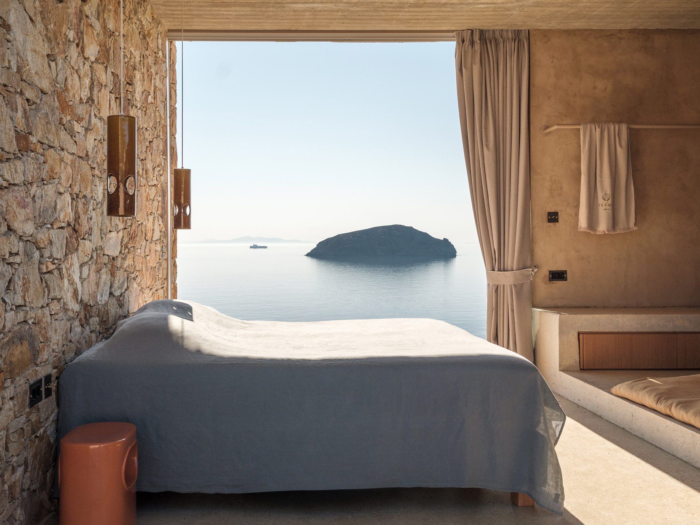 El dormitorio cuenta con paredes de piedra y grandes aberturas con vistas al mar Egeo.