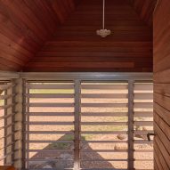 Bathroom view with louvred windows in cabin by Casey Brown architecture