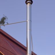 Steel chimney from pot belly stove in cabin by casey brown architecture