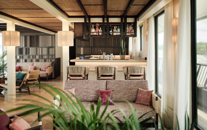 Woven panels cover the ceiling and colourful pillows feature in a bar