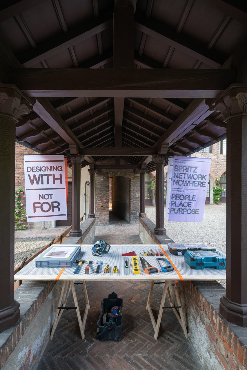 Photo of a display within the Civicity exhibition showing tools on a bench and a banner reading Designing With Not For