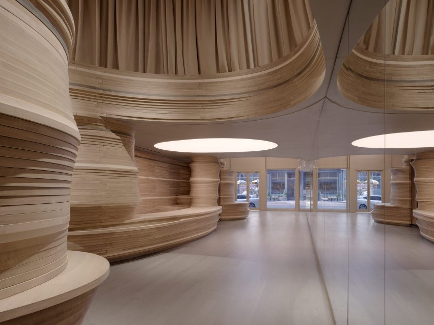 A row of mirrors runs along one side of a wood-wrapped store