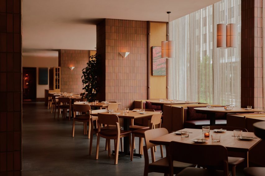 Restaurant interior with large windows, tile-wrapped columns and wooden furniture
