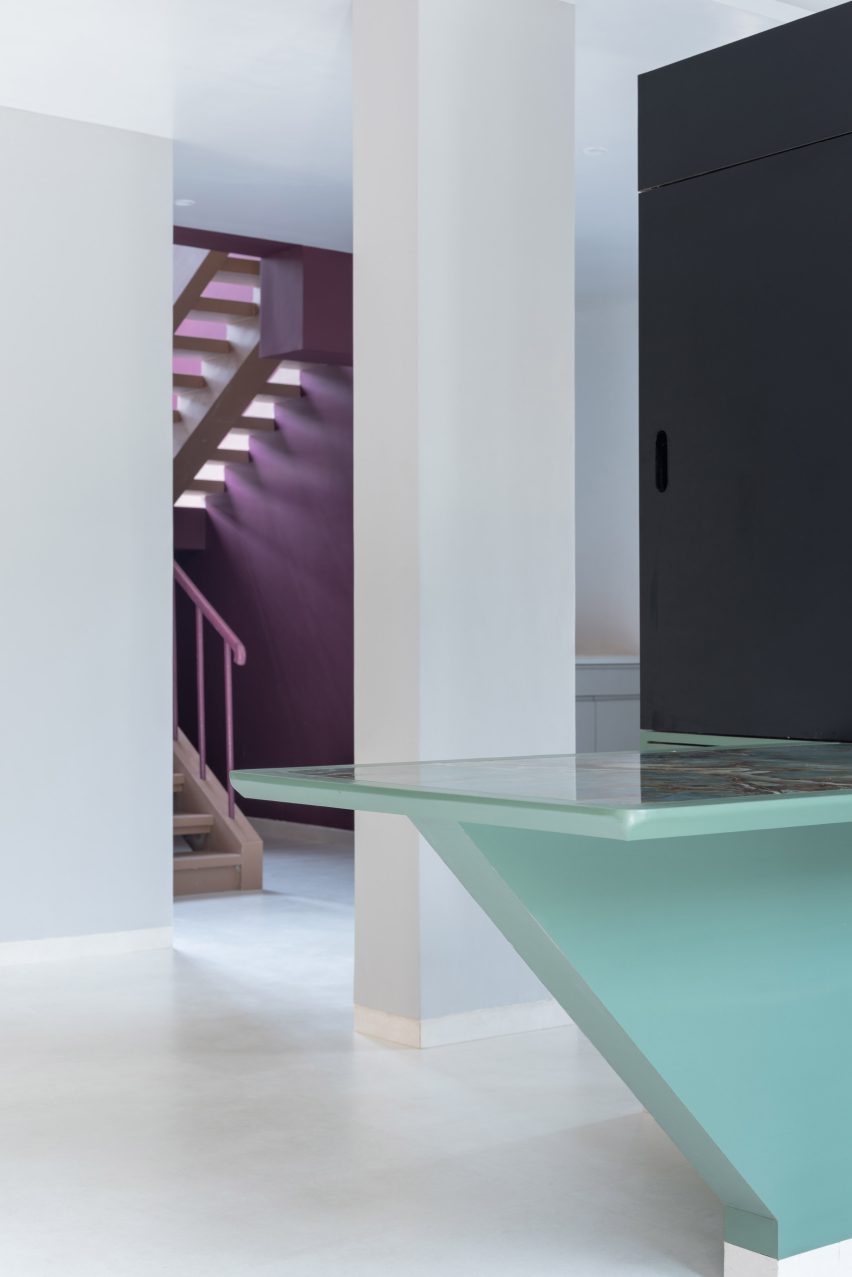 A partition acts as a dining table and television set in Villa Corsica by Neel Buddhadev