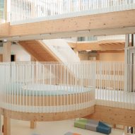 Timber-lined atrium with circular balcony and exposed structure