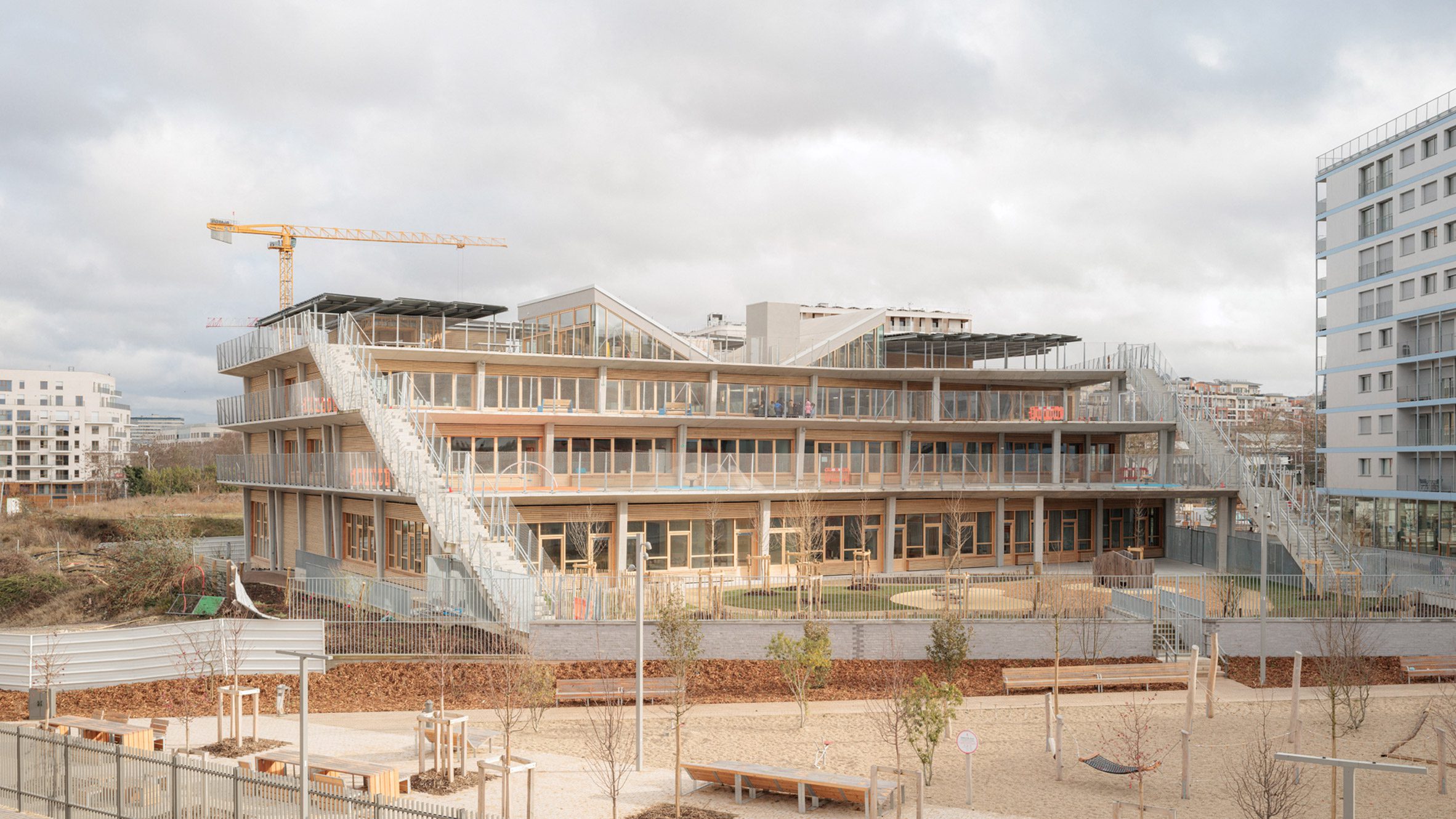 Exterior view of the stepped school building with cascading terraces and external staircases