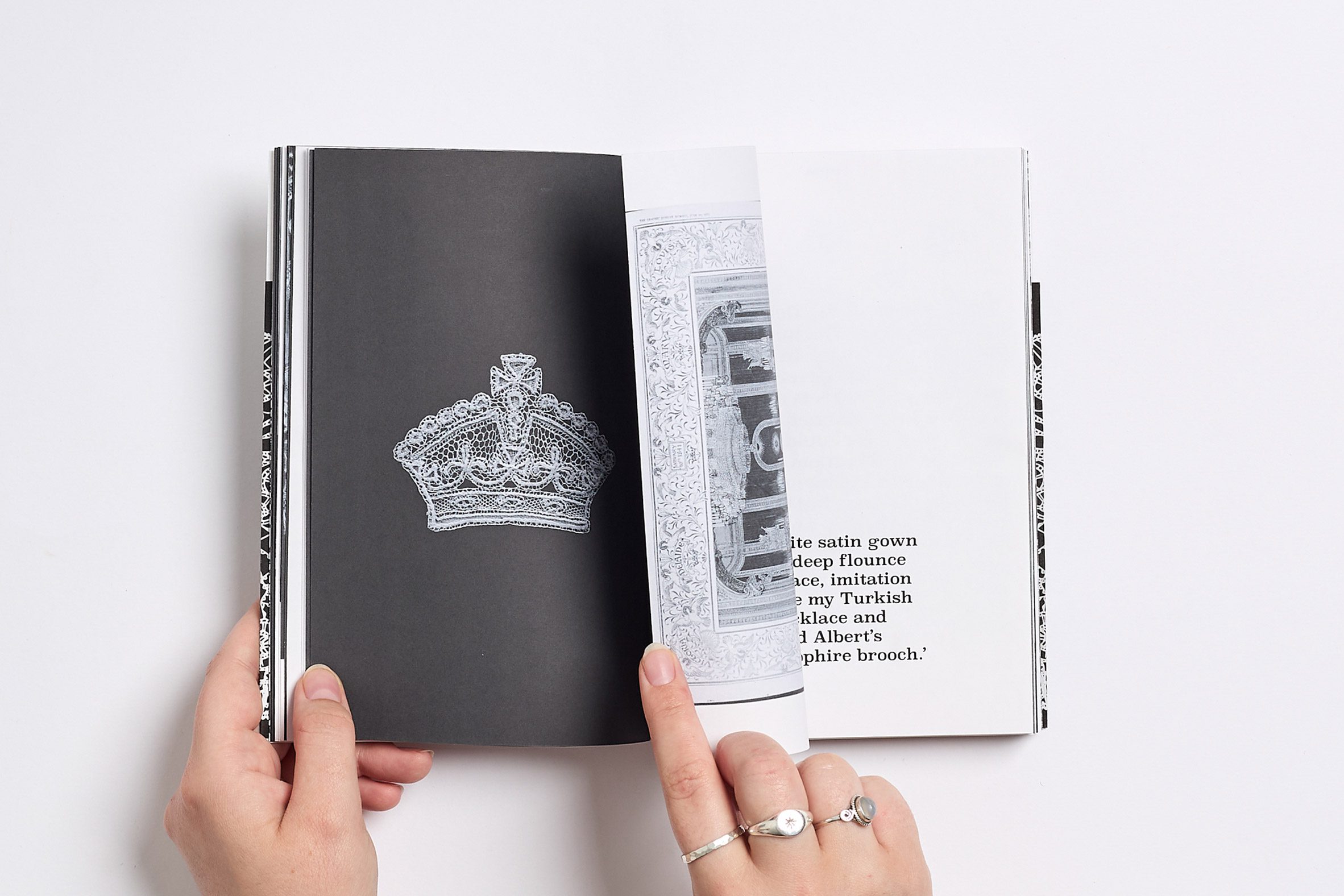 Hands leafing through book containing pictures and text about lace