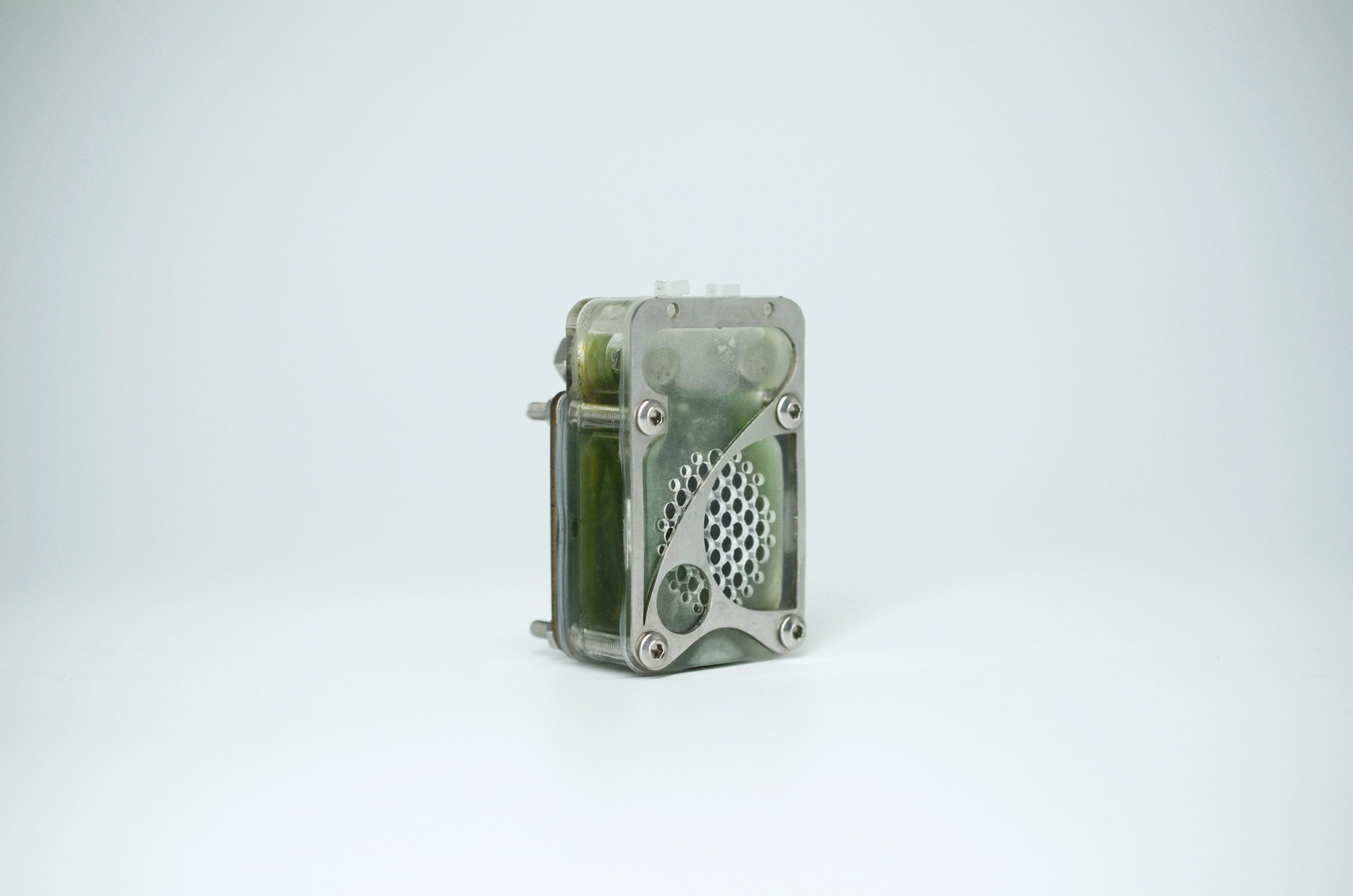 Photo of the back of the University of Cambridge's algae biocell showing a perforated transparent rectangular case filled with green goo