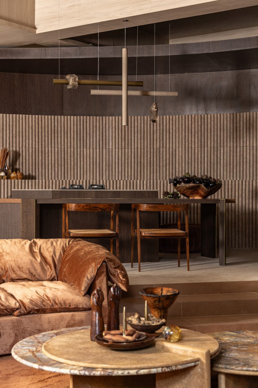 Portinari tiles form a backdrop for a custom pendant lamp and mid-century chairs