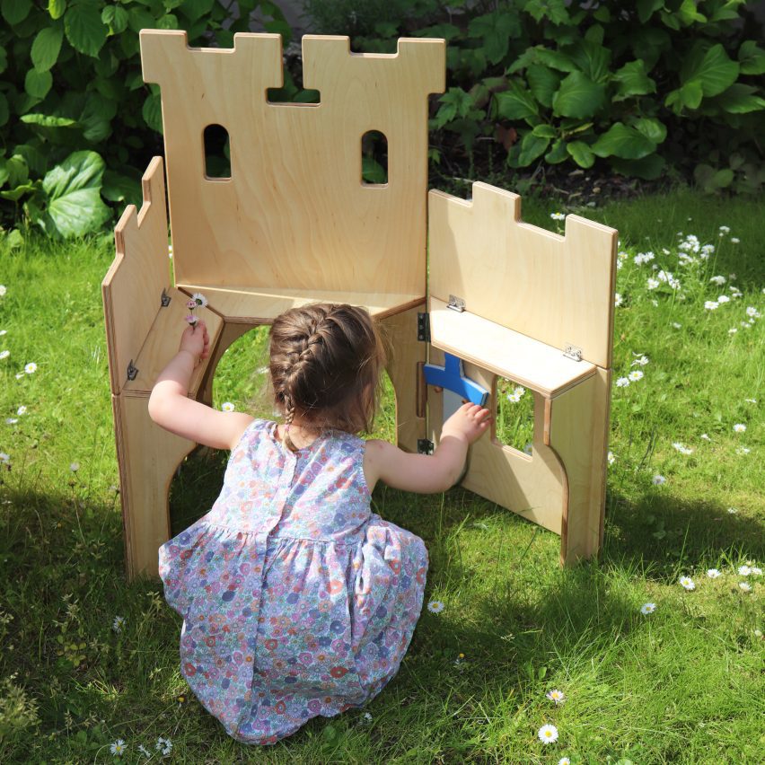 Girl taking foam sword out of plywood castle set