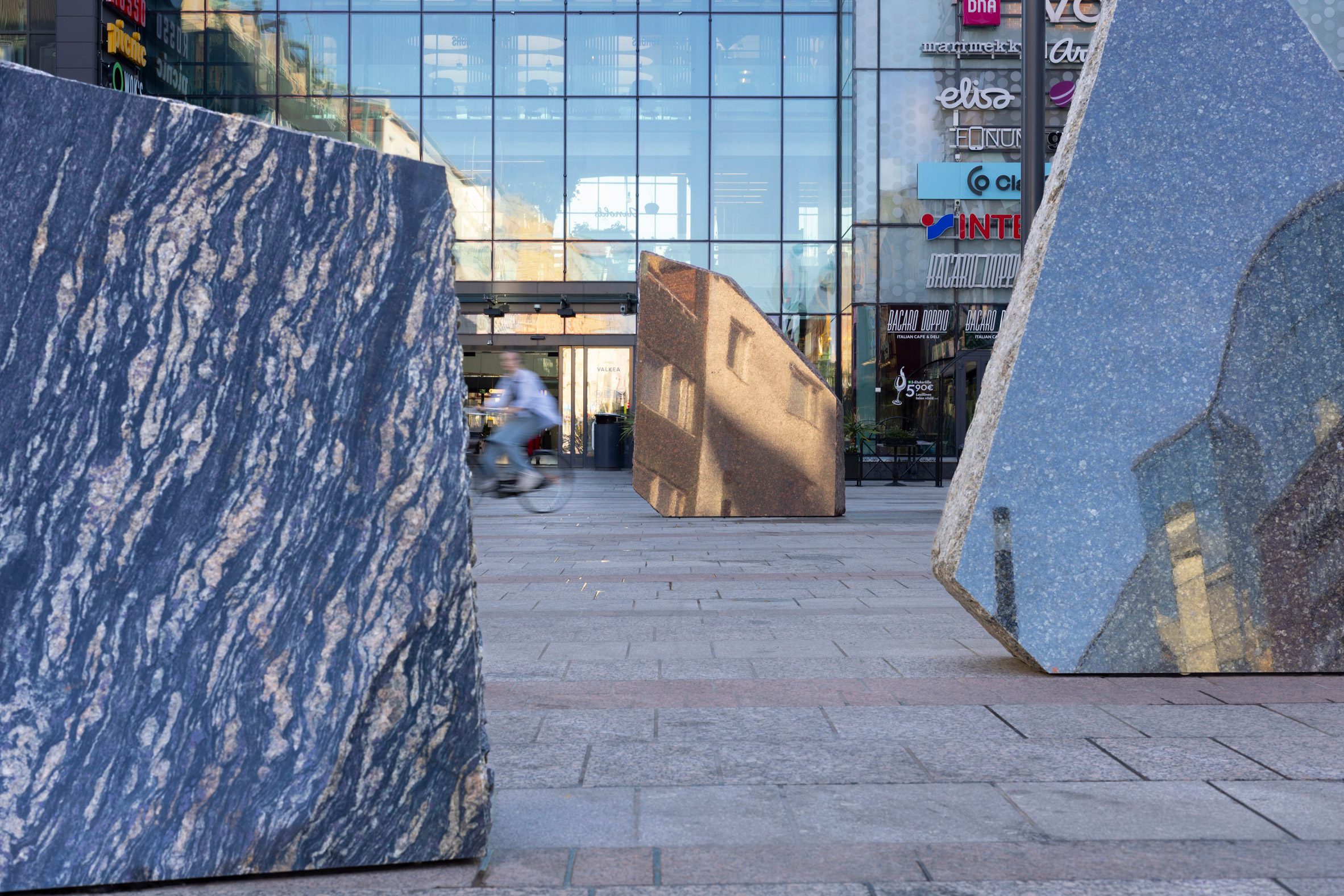 Foto de primer plano de las superficies de piedra tallada que reflejan el paisaje urbano circundante en la obra de arte en piedra número 1574 de Rana Begum ubicada en el centro de Oulu.
