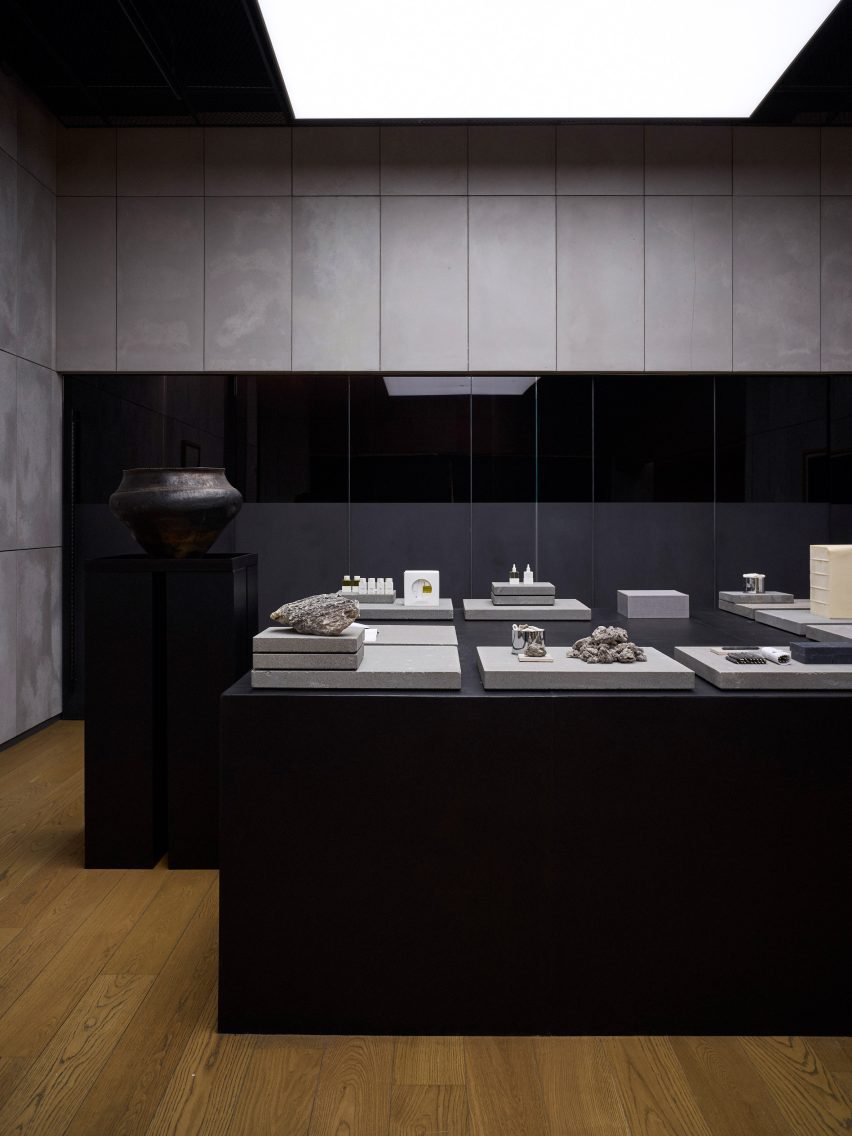 Large black-wood podiums illuminated by ceiling-mounted light boxes