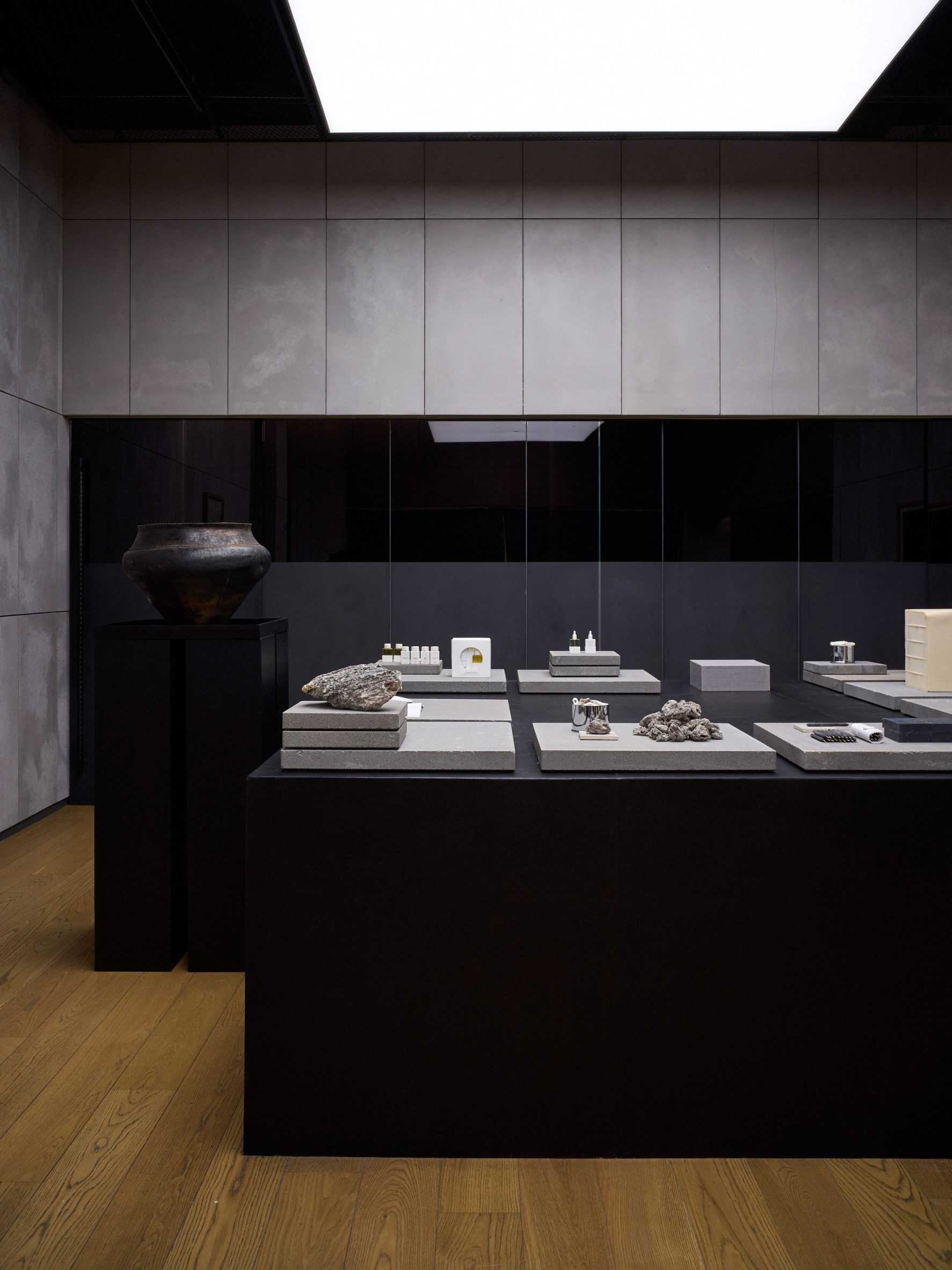Large black-wood podiums illuminated by ceiling-mounted light boxes