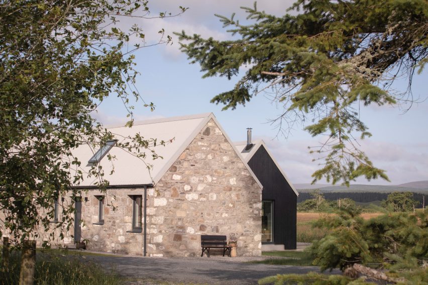 Side view of the granite cottage connected to the blackened-larch extension