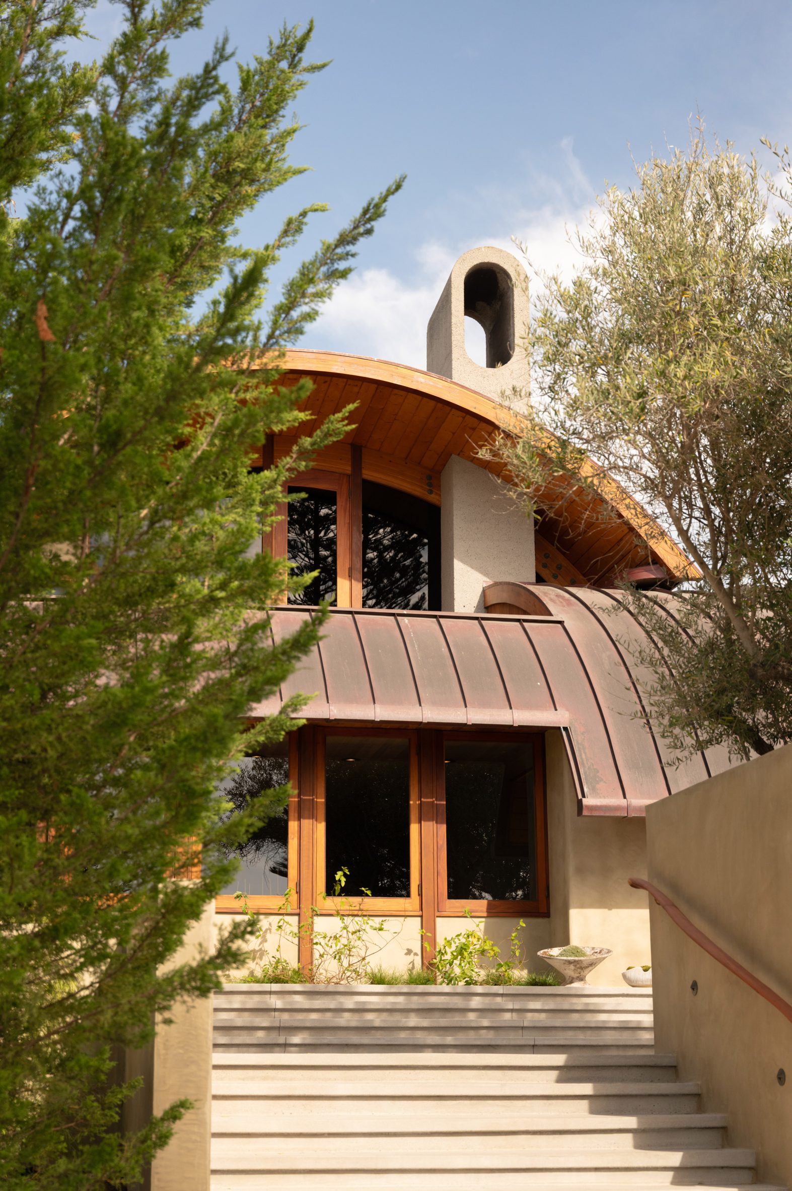 Exterior of a house with arched roofs clad in copper