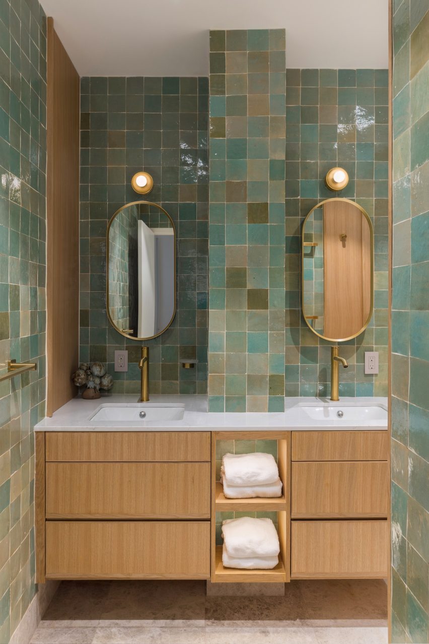Green tiles, oak millwork and brass fixtures in a bathroom