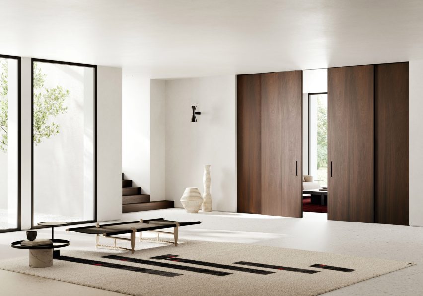 A contemporary white interior space featuring dark timber Lualdi Shoin doors and panelling at the threshold between rooms