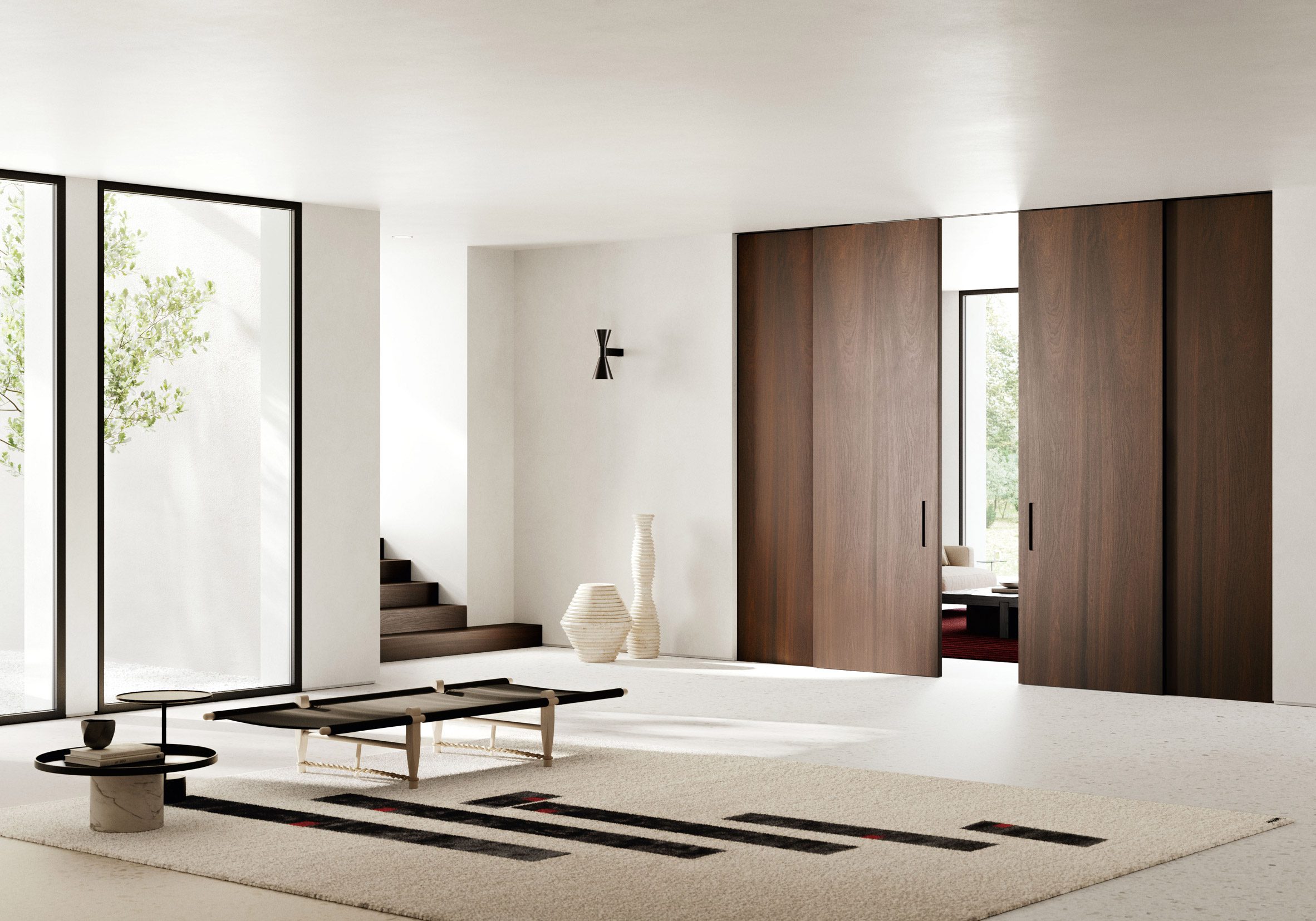 A contemporary white interior space featuring dark timber Lualdi Shoin doors and panelling at the threshold between rooms