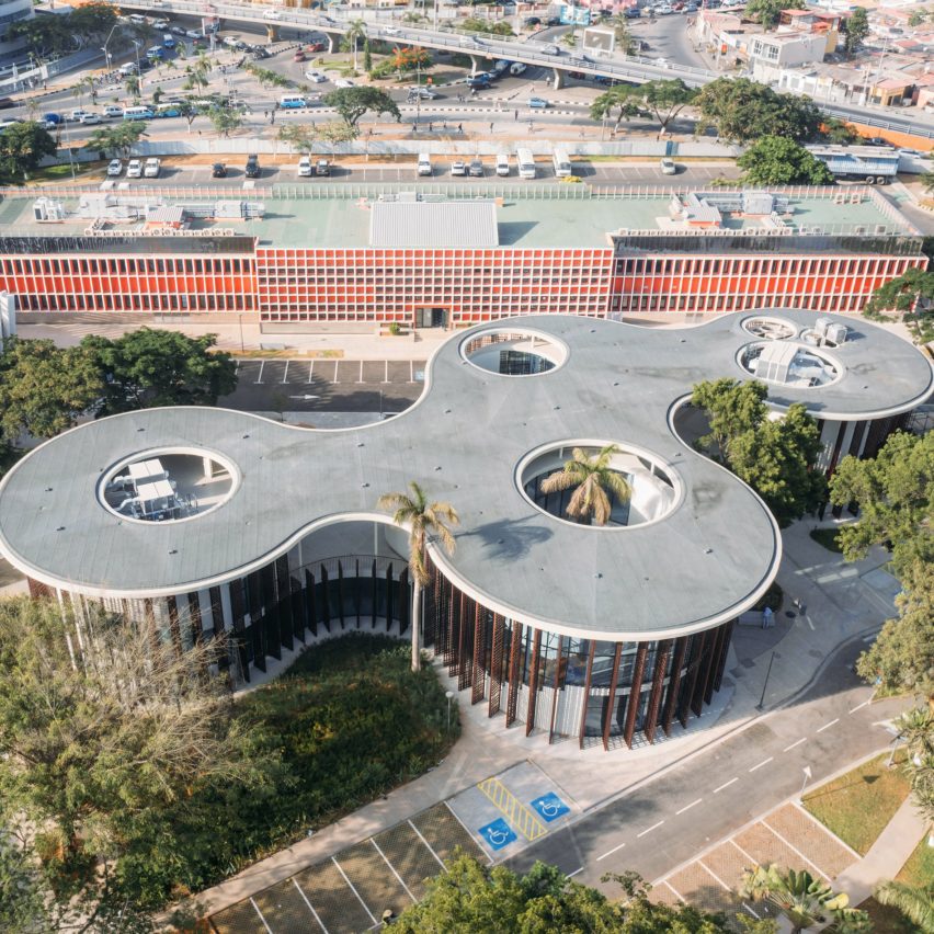 Aerial photograph showing the library's sweeping concrete canopy punctured by circular openings around preserved trees