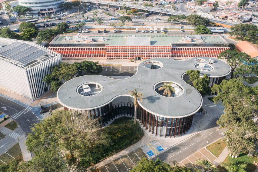 Aerial photograph showing the library's sweeping concrete canopy punctured by circular openings around preserved trees