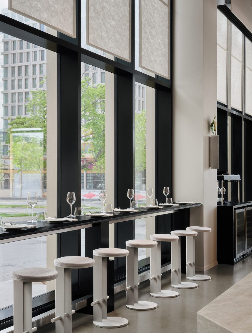 A slender black ledge along large windows provides space for dining