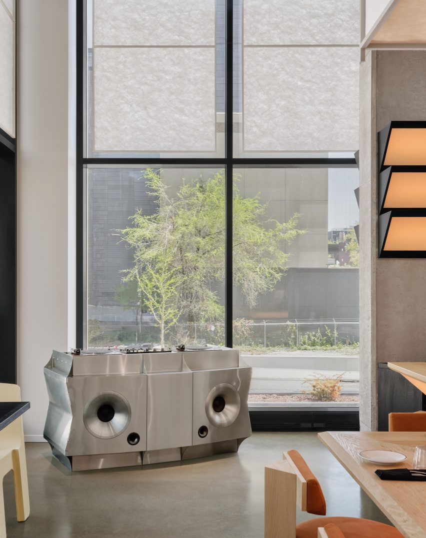 A custom stainless steel DJ booth sits at the apex of sight lines in two directions