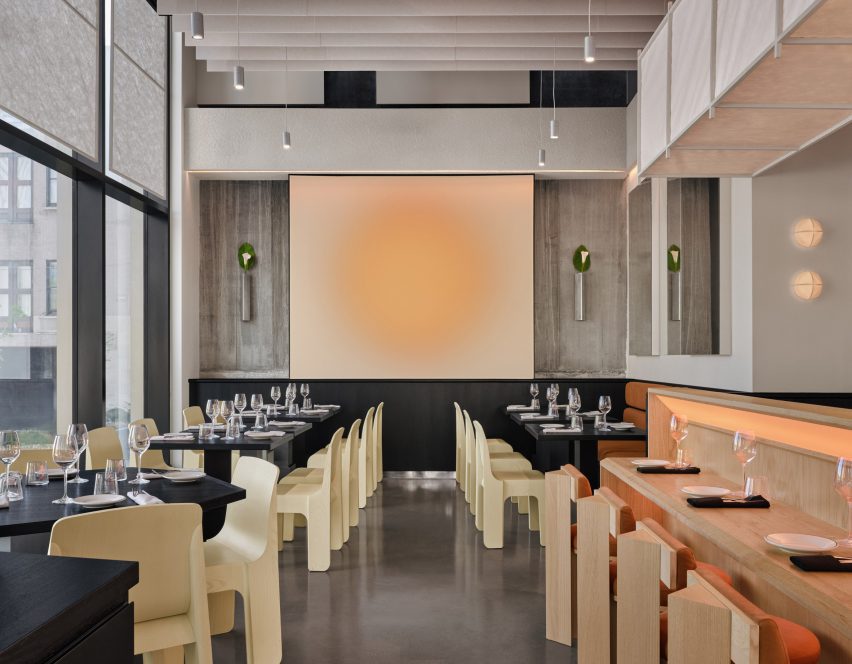 A main dining area arranged symmetrically around glowing wall-mounted artwork