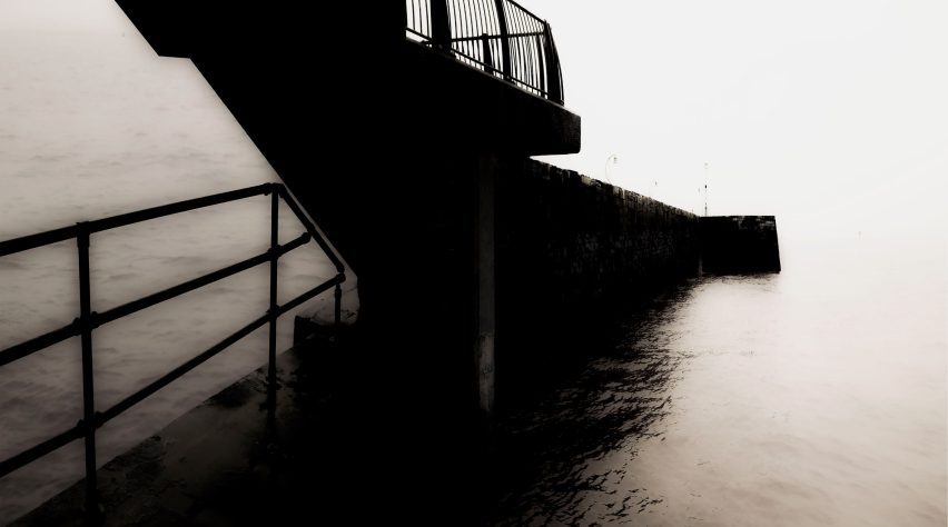Image of a structure with railing descending into a body of water
