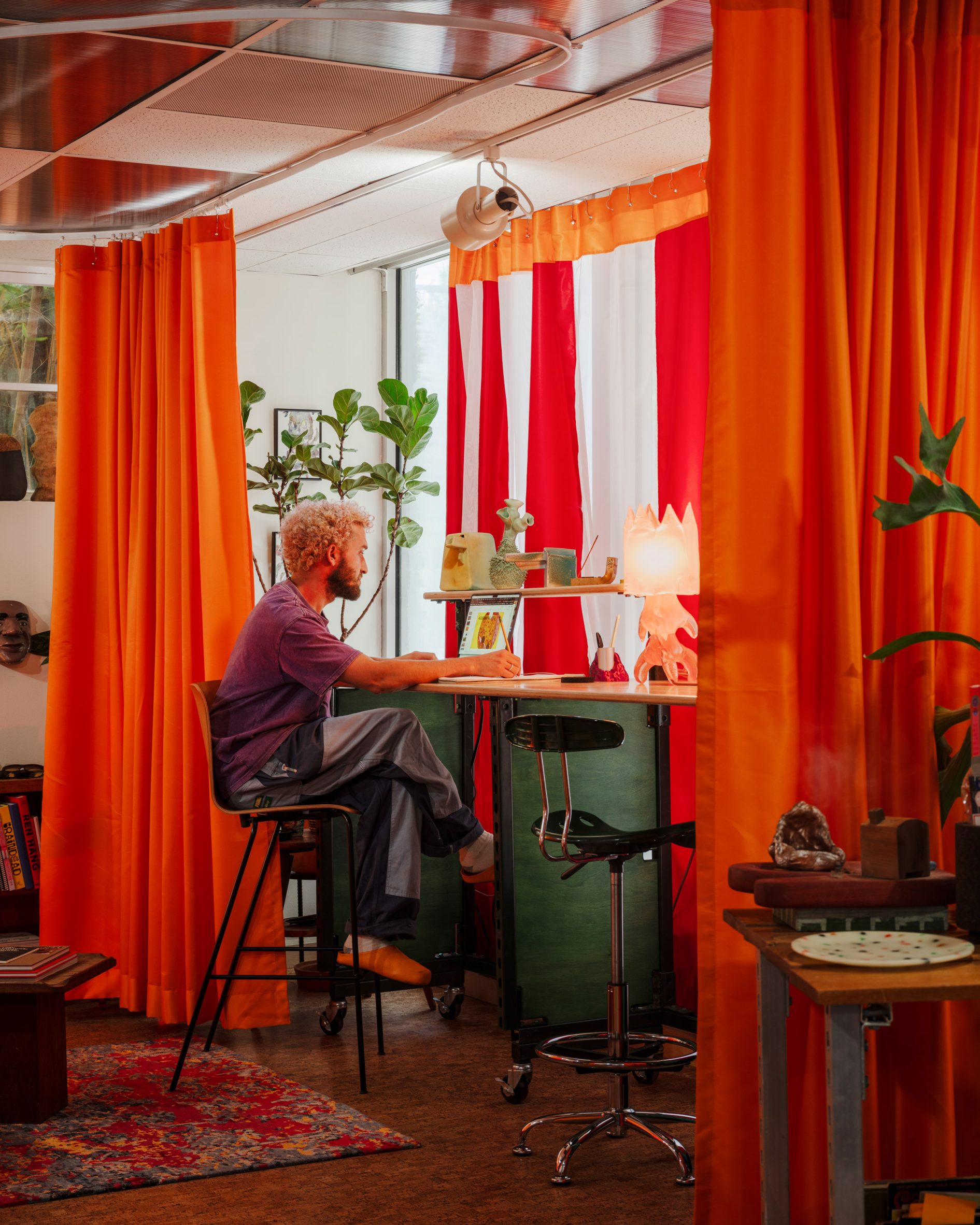 El fundador de Public Art Company, Raffi Lehrer, se sienta en el escritorio que diseñó para su estudio.