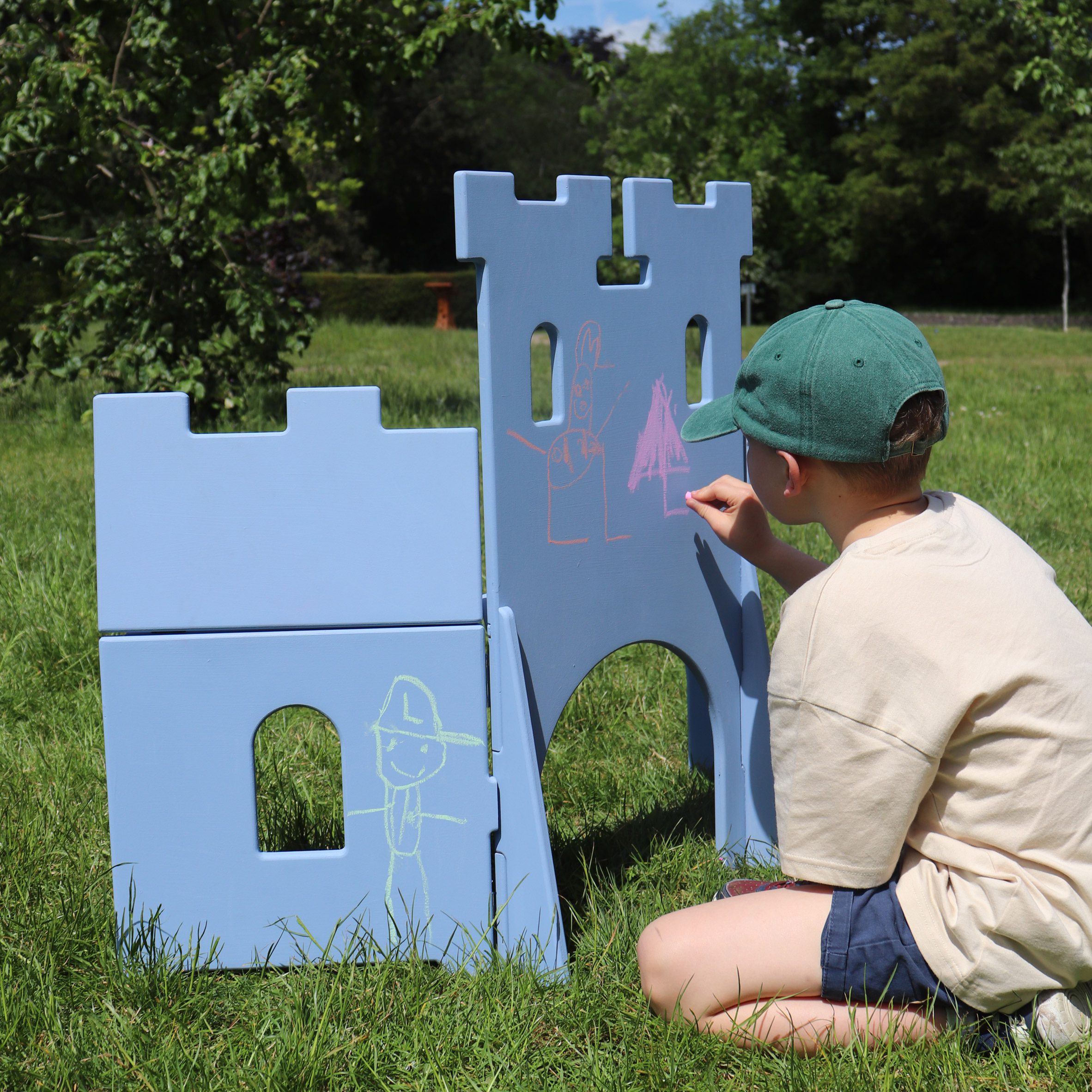 Boy drawing on a blue castle set
