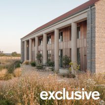 Oblique view along the length of the house showing the row of cylindrical concrete columns and landscaped garden