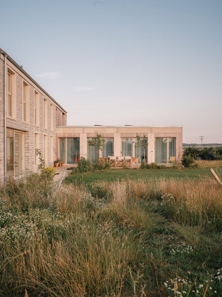 Rear elevation of the house with large glazed openings facing meadow planting and the surrounding landscape
