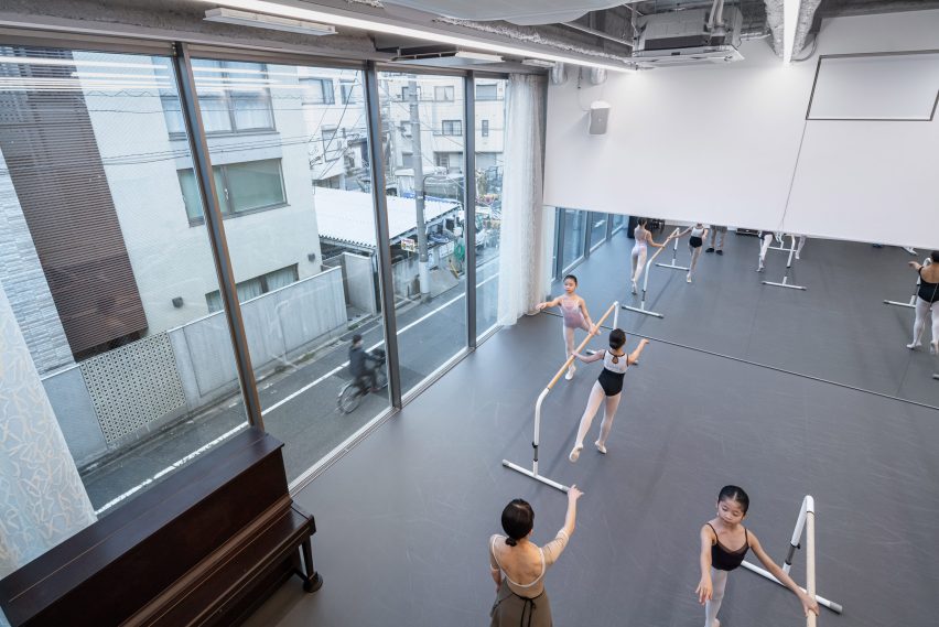 Interior of the ballet studio with dancers practising with a view overlooking the street