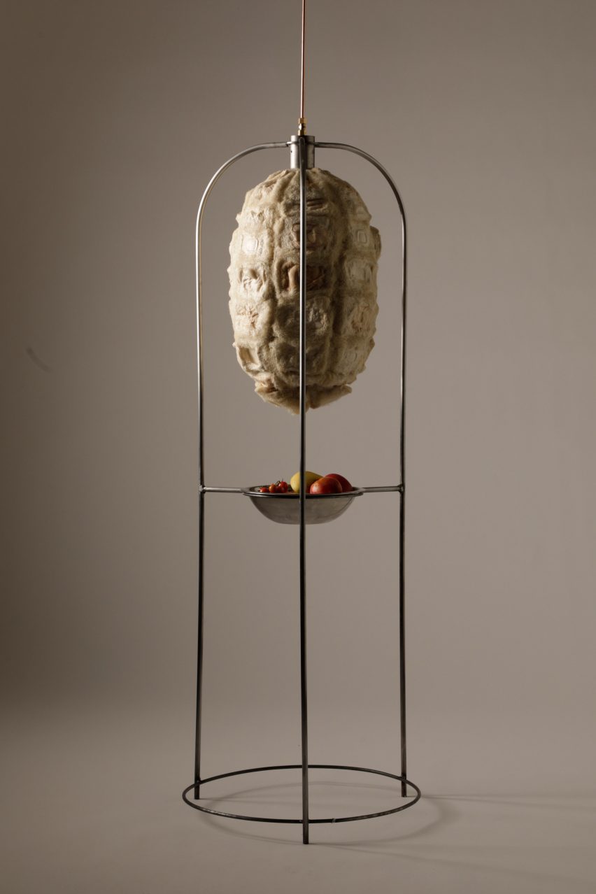 Photo of the Xero Cool bio-based fridge hanging suspended in its frame, showing a capsule made of organic-looking panels in roughly textured insulating biomaterials