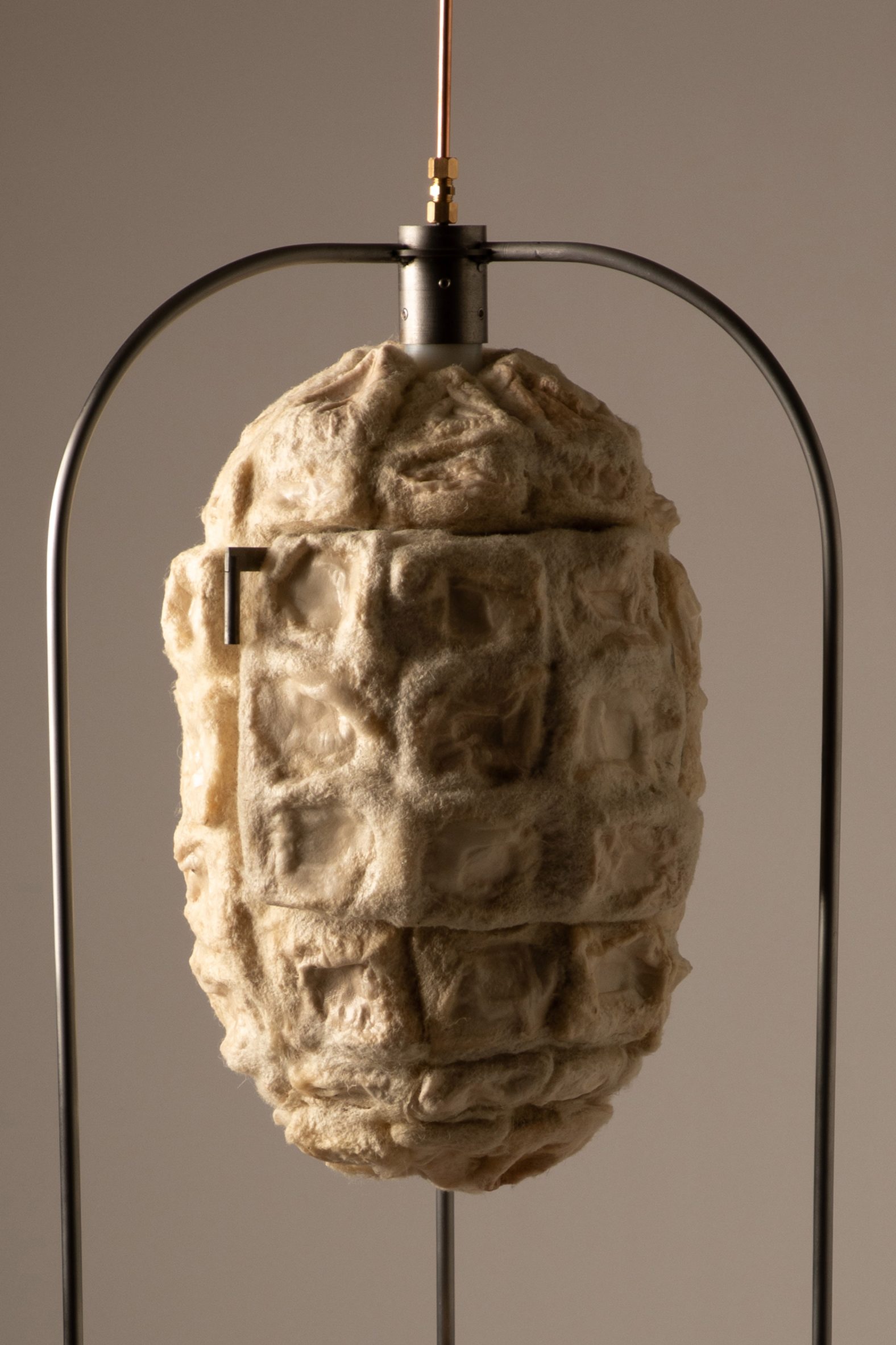 Close-up photo showing the bacterial cellulose xerogel insulating panels moulded with felted wool to make the exterior of the Xero Cool fridge, which has a cocoon-like appearance and is suspended in a frame