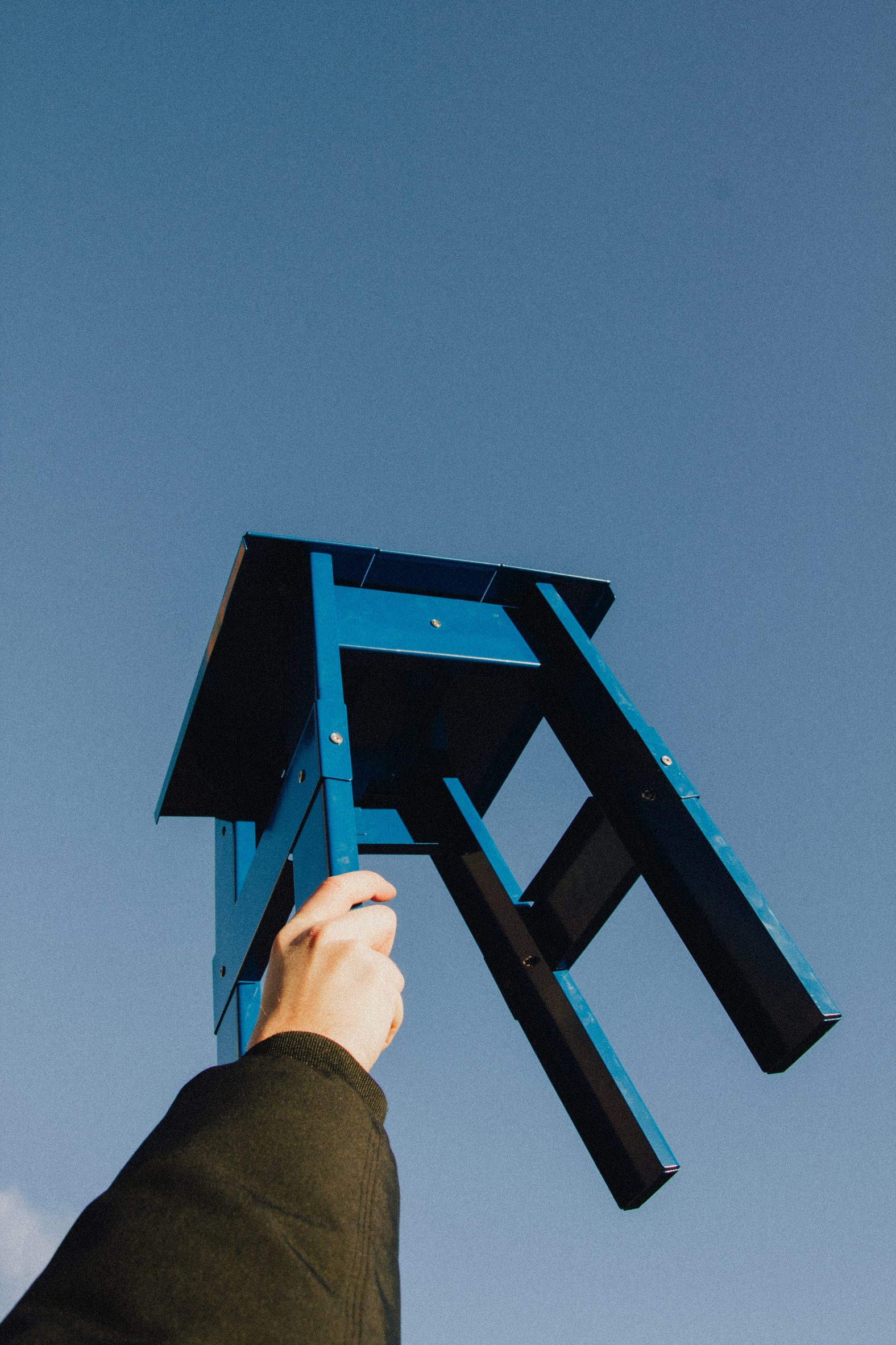 Blue stool being held towards the sky