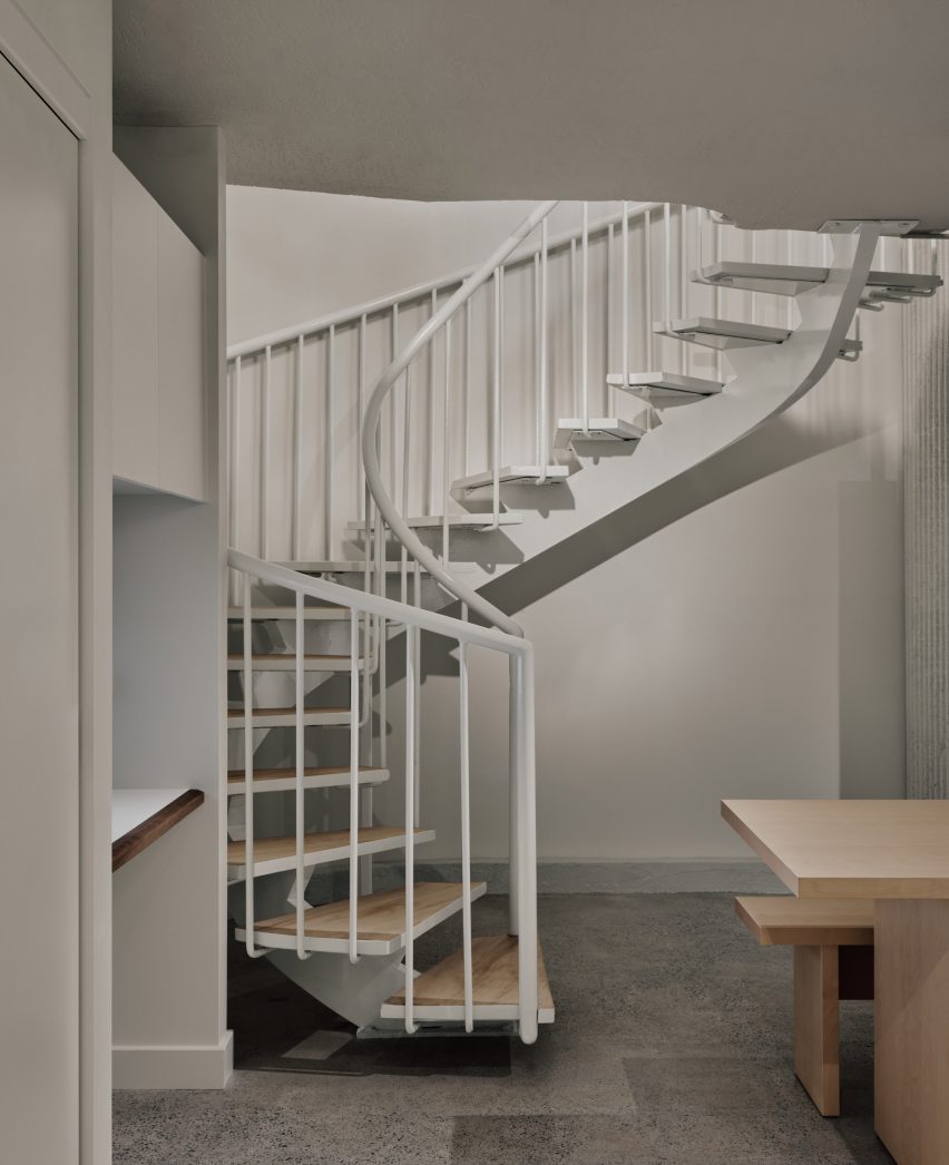 A spiral staircase leads down to a staff area in a basement